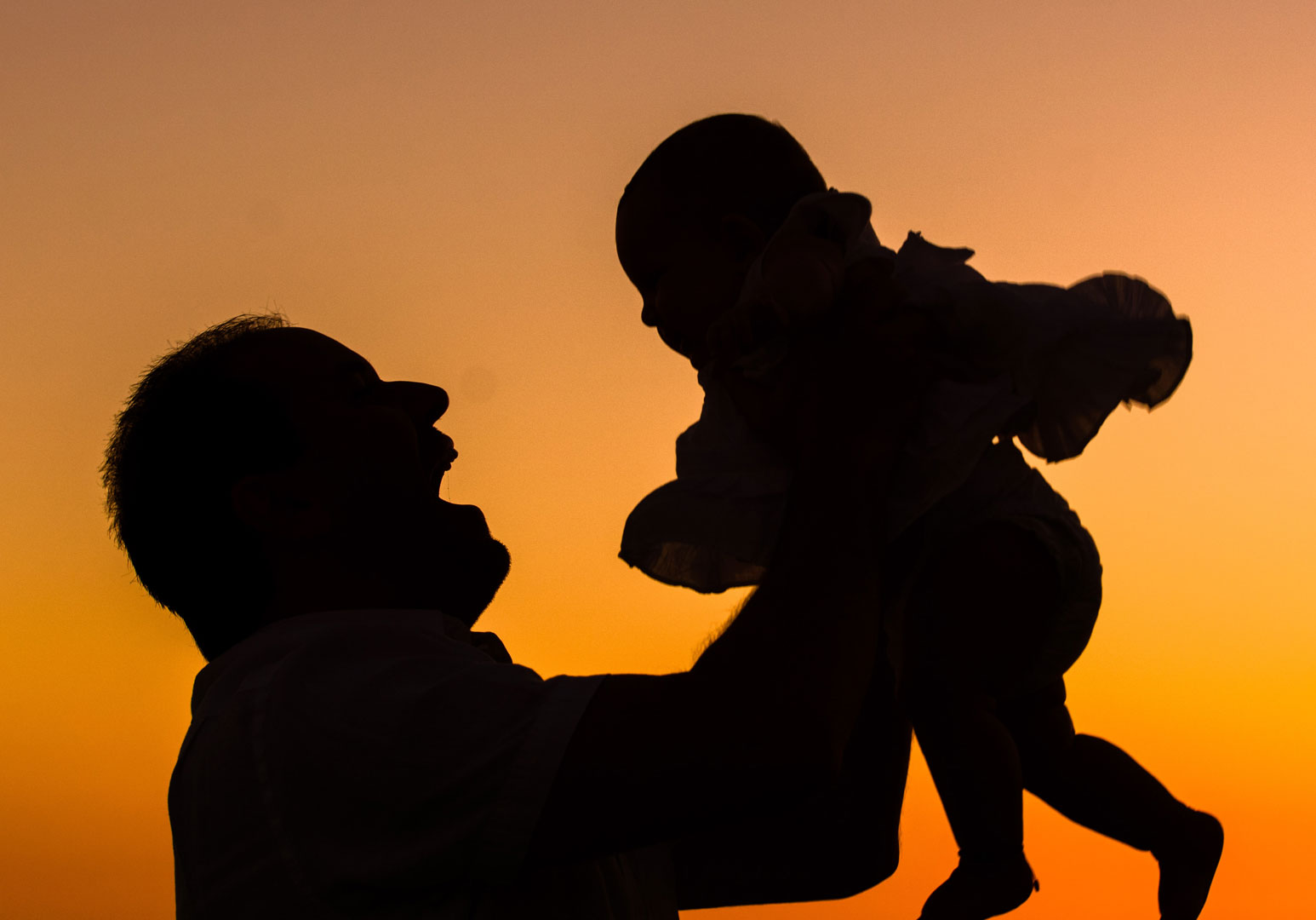 Bonding at Sunset: Father and Baby Silhouette